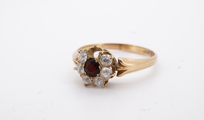 A yellow metal, garnet? and diamond set circular cluster ring (one stone missing), size P, gross weight 3 grams. Condition - poor